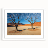 Desert landscape artwork framed in a sleek white mat, showcasing warm earthy tones and intricate details of the arid scenery, perfect for home decor.