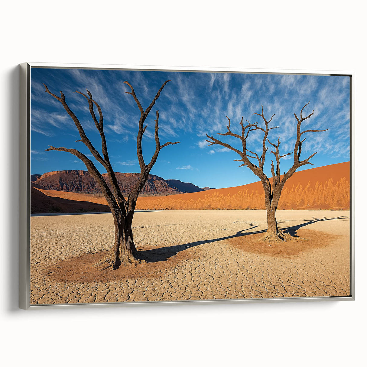 Desert landscape framed canvas artwork showcasing warm hues of orange and yellow under a clear blue sky, featuring a sleek silver frame that enhances the vibrant scene. Perfect for modern home decor, adding a touch of nature-inspired elegance.