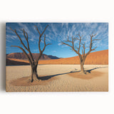 Vibrant stretched canvas artwork depicting a serene desert landscape at sunset, highlighting warm orange and yellow hues against a tranquil blue sky, perfect for home decor.