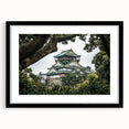 Black-framed landscape artwork showcasing a majestic castle surrounded by lush greenery, elegantly matted for a refined presentation, perfect for home decor.