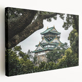 Stretched canvas artwork depicting a scenic landscape with a majestic castle surrounded by lush greenery and a clear blue sky. Ideal for home decor enthusiasts.