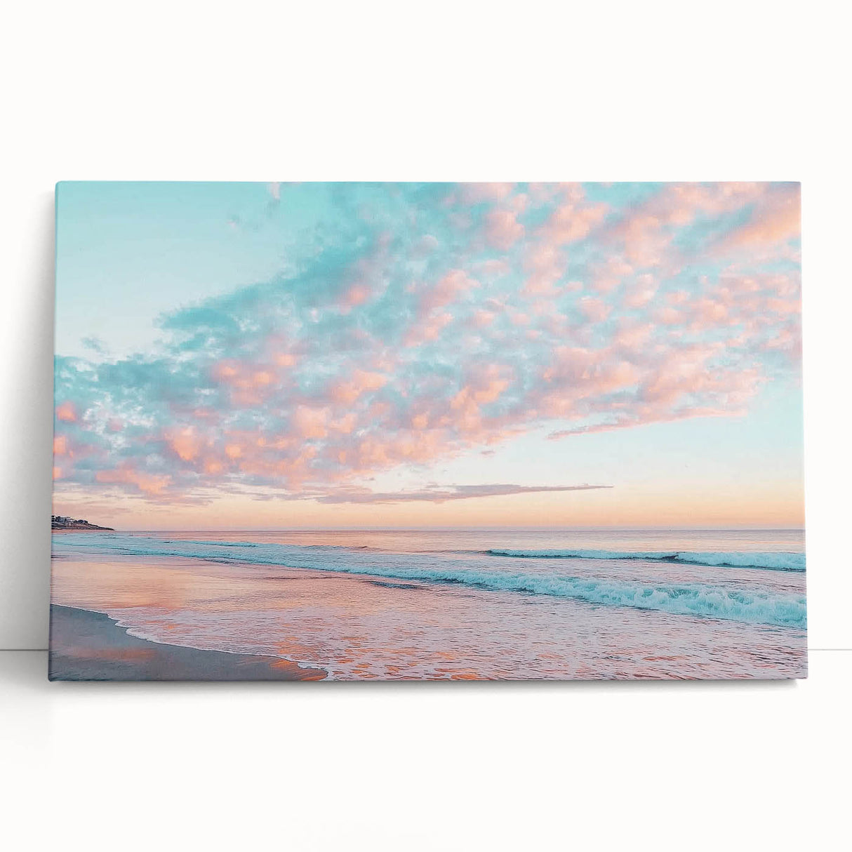 Stretched canvas artwork depicting a serene beach landscape with soft pastel colors, leaning against a neutral wall, perfect for home décor. Ideal for coastal-themed interiors.