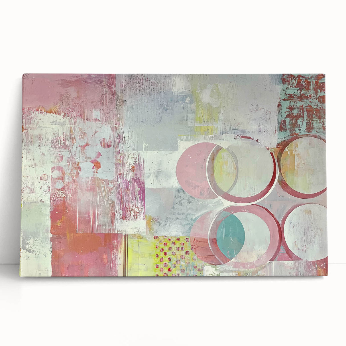 Abstract canvas art featuring vibrant strokes in blue, pink, and gold hues, leaning against a neutral wall, adding a modern touch to home decor.