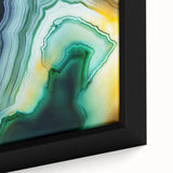 Close-up of a framed canvas showcasing vibrant abstract strokes in shades of blue, orange, and yellow, ideal for modern home decor and art lovers.
