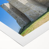 Colorful rolled canvas artwork depicting a serene landscape with a majestic castle surrounded by lush greenery and a clear blue sky, ideal for home decor.