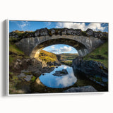 Framed canvas artwork depicting a serene landscape bridge scene, showcased from a side view with a white frame, perfect for home decor and artistic ambiance.