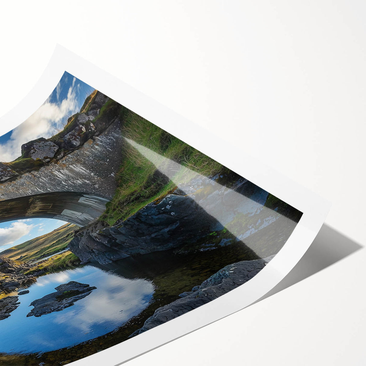 Landscape bridge rolled print showcasing a serene river scene with lush greenery and a clear blue sky, packaged securely in a protective cardboard tube for easy transport.
