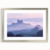 Elegant silver-framed landscape artwork depicting a majestic castle surrounded by lush greenery, presented with a white mat for added sophistication. Perfect for home decor.