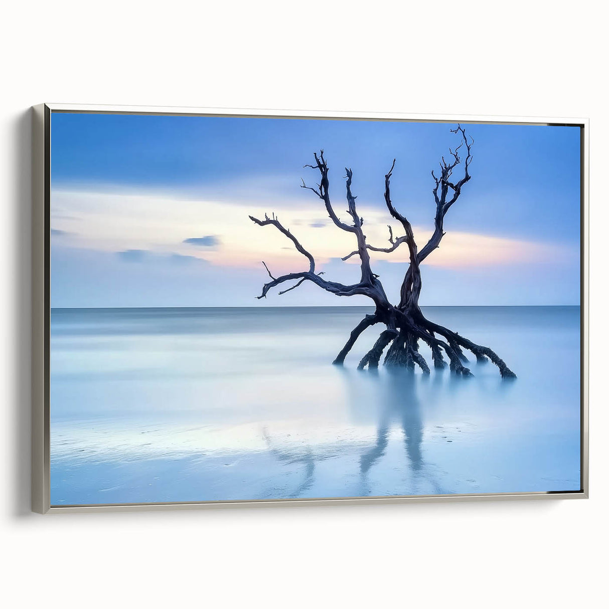Framed canvas artwork showcasing a serene beach landscape with soft waves and a vibrant sunset, featuring a sleek silver frame that enhances its modern aesthetic. Perfect for coastal-themed decor.