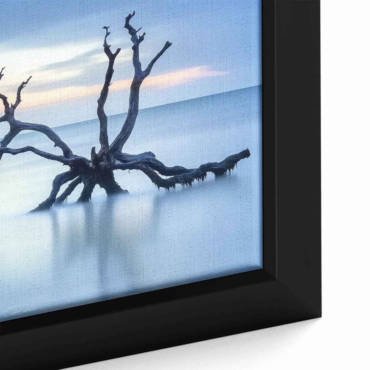 Close-up of a framed canvas artwork depicting a serene beach landscape with gentle waves, vibrant blue skies, and soft sand, perfect for coastal home decor.