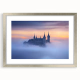 Silver-framed landscape artwork featuring a picturesque castle scene, elegantly matted with a soft white border, ideal for home decor or gallery display.