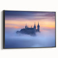 Framed canvas artwork depicting a majestic castle landscape, featuring intricate details and vibrant colors, showcased with a sleek black frame for an elegant aesthetic.