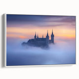 Framed canvas artwork showcasing a picturesque landscape with a majestic castle nestled among lush greenery, set against a serene sky. The piece features a classic white frame, enhancing its elegant presentation for home or office decor.