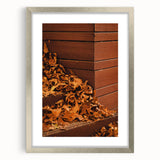Textured abstract art print depicting autumnal colors in a silver frame, suitable for bedroom ambiance.
