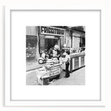 Abstract art print featuring stylized food and people in muted pastel shades, framed with a white mat.