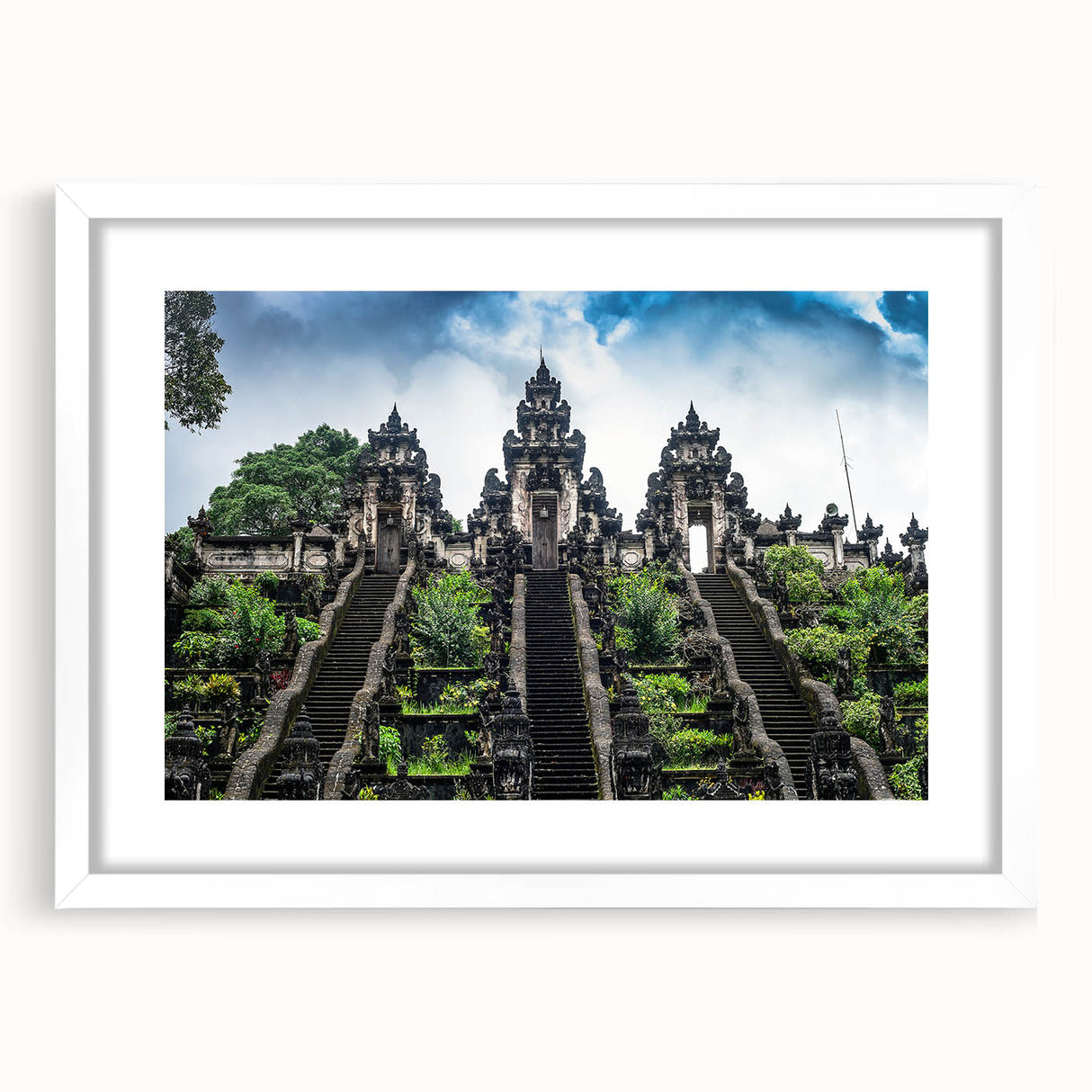 Abstract art print of an Indonesian landscape in muted green and brown tones, framed in white.