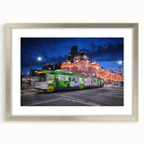 Abstract art print of Melbourne skyline in muted gray and blue tones on a silver-framed matte canvas.