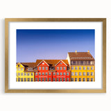 Abstract art print of a European scenery in muted gold and blue tones, framed with a gold mat.
