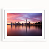 Abstract art print of Auckland skyline in muted blues and greens on a framed white mat, ideal for dining room decor.