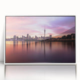 Art deco poster of Auckland skyline in muted gray and blue tones, acrylic print in white frame.