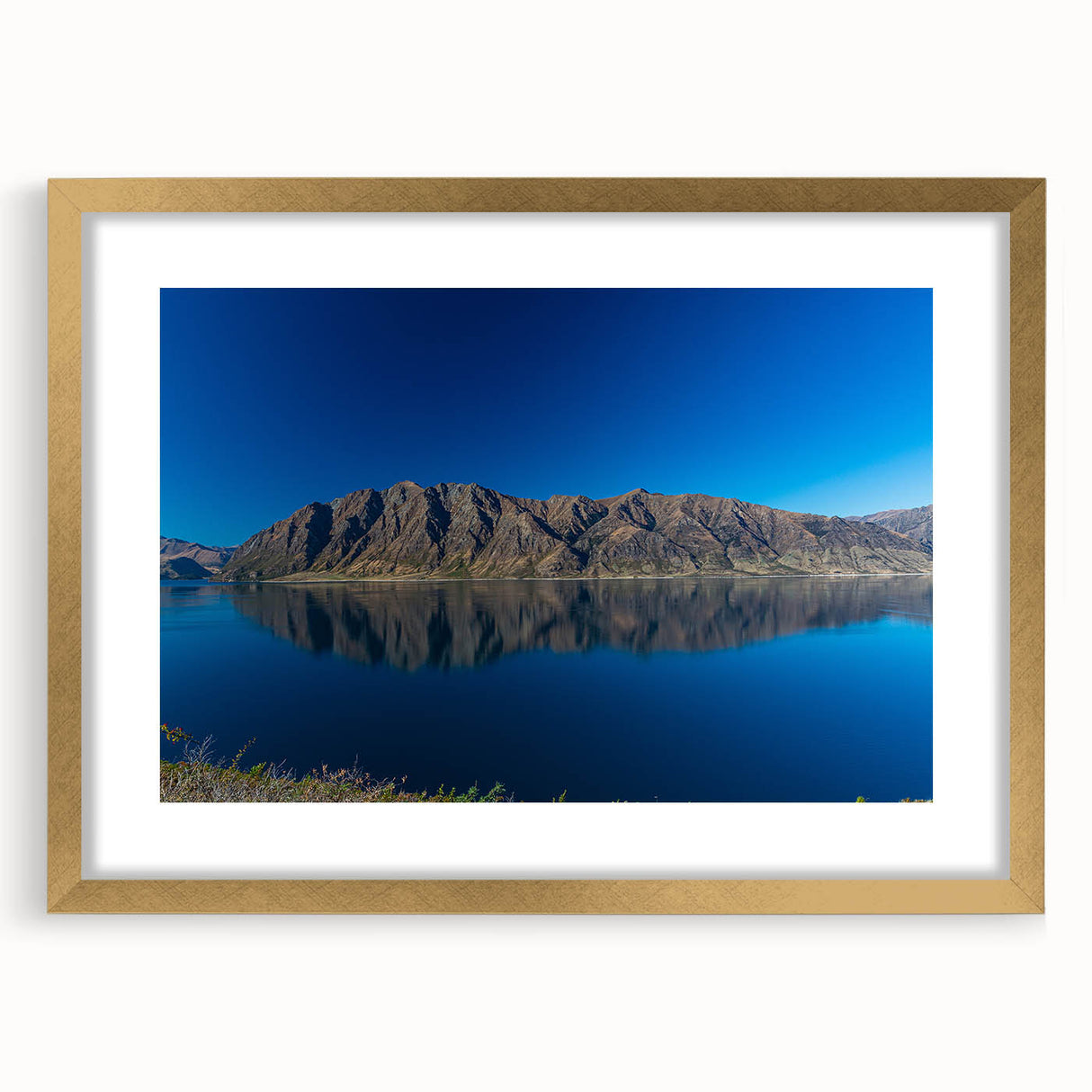 Extra large abstract art print of Otago, New Zealand, in gold frame, featuring textured blues and greens.
