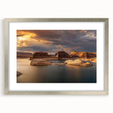 Textured art depicting abstract Lake Powell in muted blue and tan shades on a framed silver mat, suited for bedroom decor.