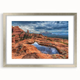 Textured art print of Sedona's landscape in muted earth tones on a silver-framed mat, ideal for bedroom ambiance.