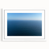 Abstract art print of Santa Monica scenery in muted blue and white tones on a framed canvas, suitable for dining room decor.