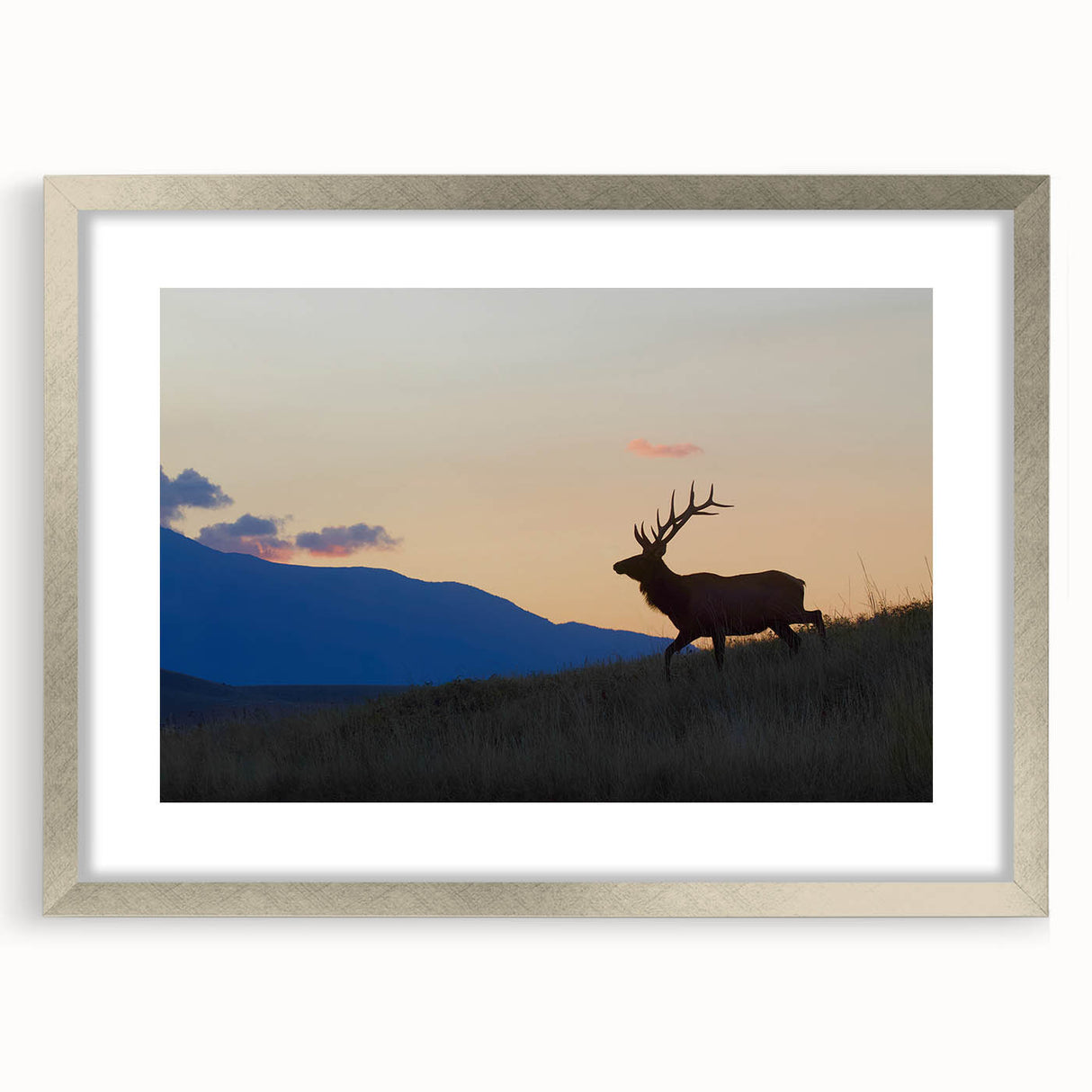 Textured art print depicting the Rocky Mountains in muted earth tones, framed in silver, ideal for bedroom decor.