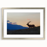 Textured art print depicting the Rocky Mountains in muted earth tones, framed in silver, ideal for bedroom decor.