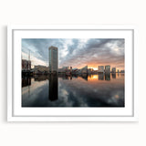 Abstract art print of Baltimore skyline in muted gray and blue tones on a framed white mat, suitable for dining room decor.