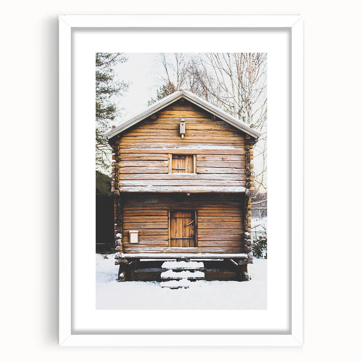 Abstract art print depicting a winter scene in muted blue and white tones, framed with a white mat.