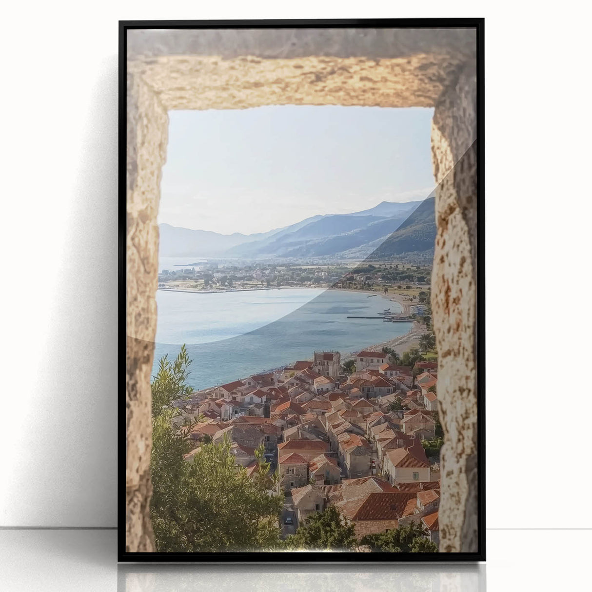 Framed acrylic artwork showcasing a picturesque landscape with a castle surrounded by lush greenery, presented in a sleek black frame, ideal for home decor.