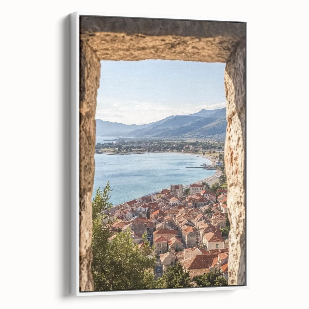 Framed canvas artwork depicting a serene landscape with a majestic castle surrounded by lush greenery, showcased in a sleek white frame for a modern aesthetic.