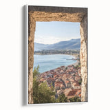 Framed canvas artwork depicting a serene landscape with a majestic castle surrounded by lush greenery, showcased in a sleek white frame for a modern aesthetic.