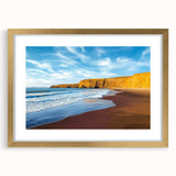 Elegant gold-framed landscape art print showcasing dramatic cliffs under a vivid blue sky, highlighted by a white mat, perfect for enhancing home decor.