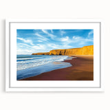 White-framed landscape artwork showcasing a dramatic cliff scene with vivid colors, perfect for home decor, displayed in a bright, modern setting.