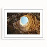 Framed landscape artwork depicting a serene cave scene with neutral tones and a white mat, showcasing intricate details, perfect for home decor.