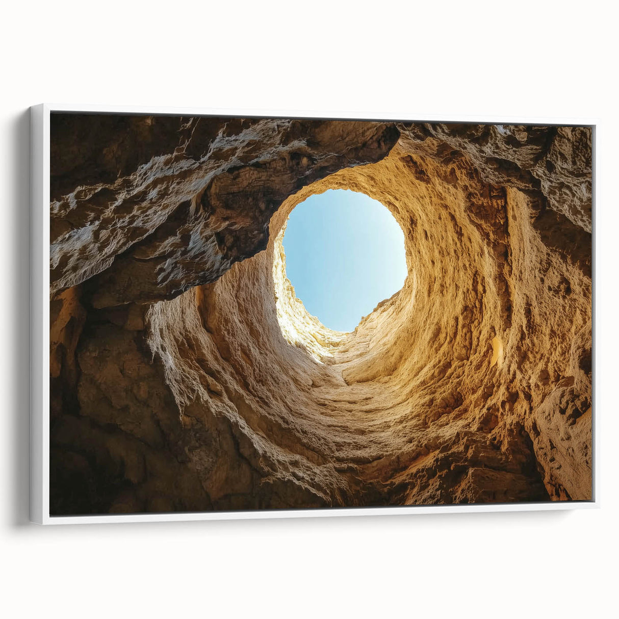 Framed canvas artwork depicting a serene landscape with caves, featuring earthy tones and intricate details, elegantly displayed against a white background.