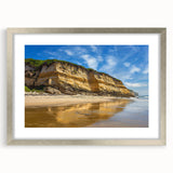 Silver-framed landscape artwork showcasing dramatic cliffs and serene ocean waves, elegantly matted for an enhanced visual presentation, ideal for home decor.