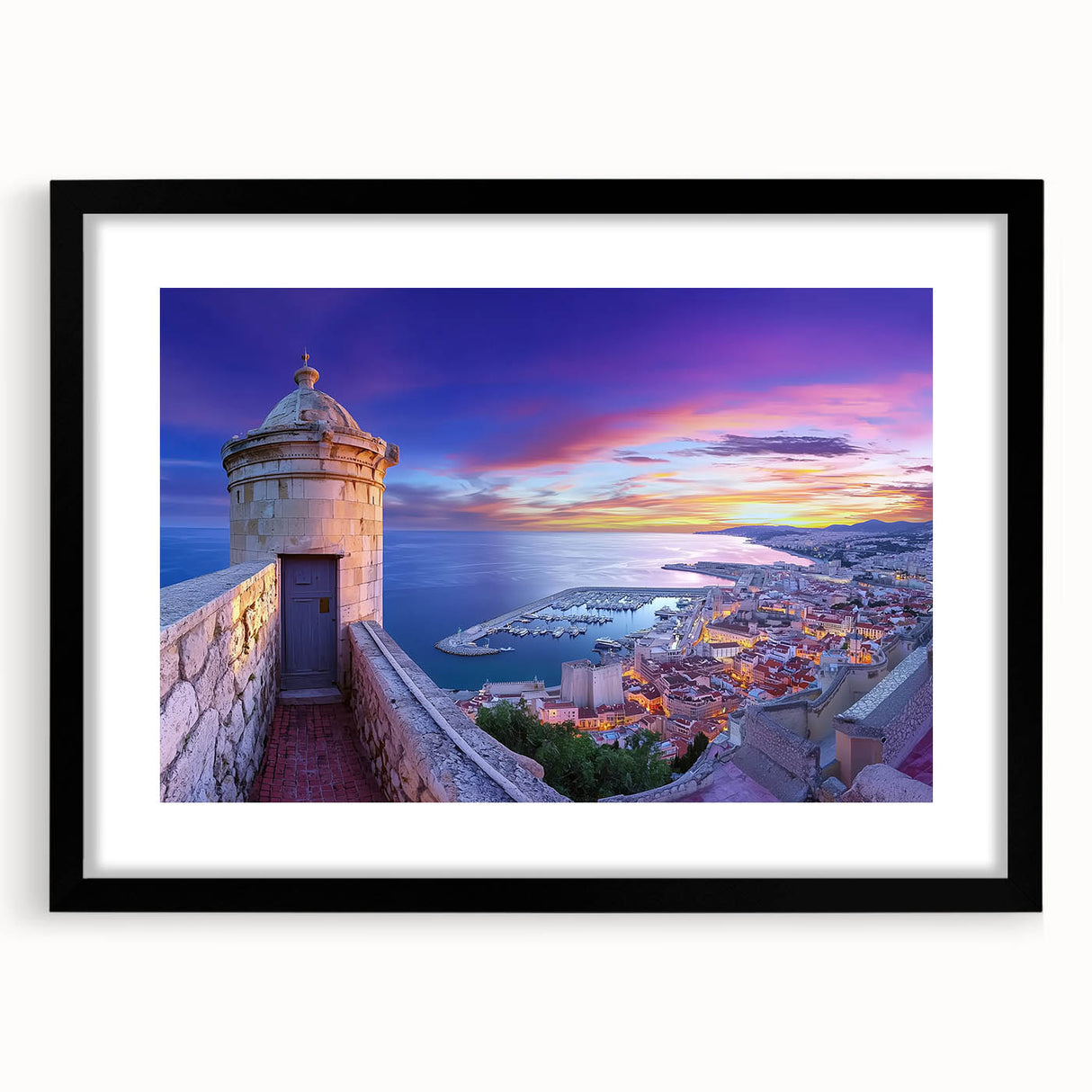 Black-framed landscape artwork depicting a majestic castle surrounded by lush greenery, showcased with a white mat for an elegant presentation. Perfect for home decor.
