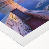 Rolled canvas artwork showcasing a picturesque landscape with a majestic castle surrounded by lush greenery, elegantly packaged in a protective cardboard tube for safe delivery.