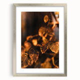 Textured abstract art print in warm autumn hues on a framed silver mat, ideal for bedroom ambiance.
