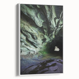 Framed canvas artwork depicting a serene landscape with caves, featuring earthy tones and textures, showcased from a side view against a white background. Ideal for home decor enhancement.
