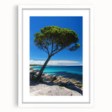 Framed landscape artwork depicting dramatic cliffs, surrounded by a white mat, showcasing natural beauty and serene colors, perfect for home decor.