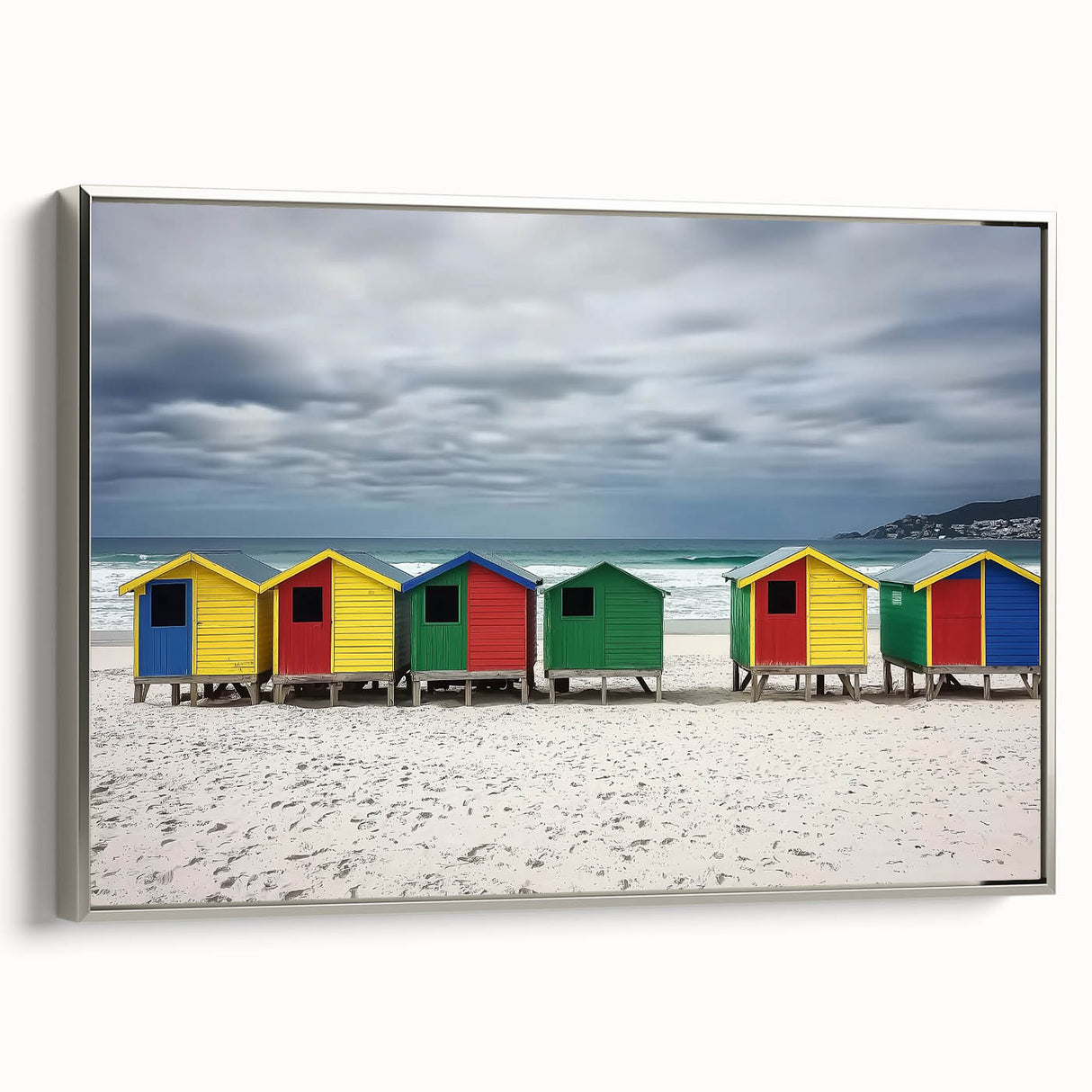 Framed canvas artwork depicting a serene beach landscape with soft waves and blue skies, elegantly bordered in silver, ideal for coastal-themed decor.