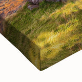 Close-up of a stretched canvas showcasing a vibrant landscape with dramatic cliffs and rich colors, ideal for home decor and artistic interiors.