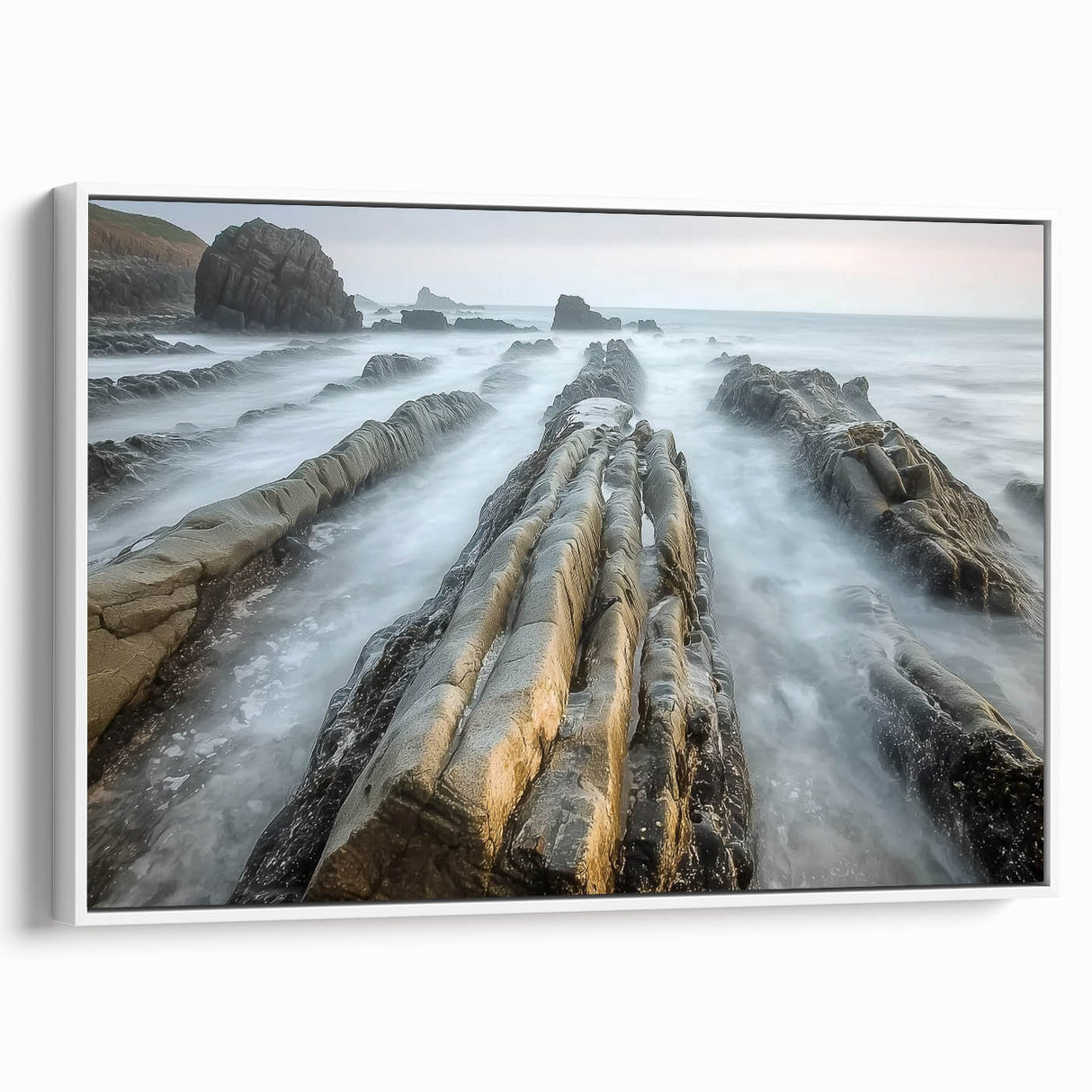 Framed landscape canvas depicting serene beach scenery with soft waves, vibrant blue sky, and white frame, perfect for coastal home decor.