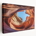 Stretched canvas artwork depicting a stunning landscape of canyons with vibrant hues of orange and red under a clear blue sky, ideal for home decor and art enthusiasts.
