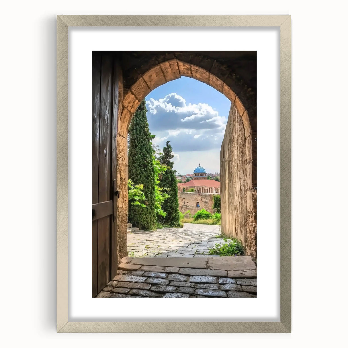 Framed landscape artwork depicting a majestic castle surrounded by lush greenery, featuring a silver matting that enhances its elegance, perfect for home decor.
